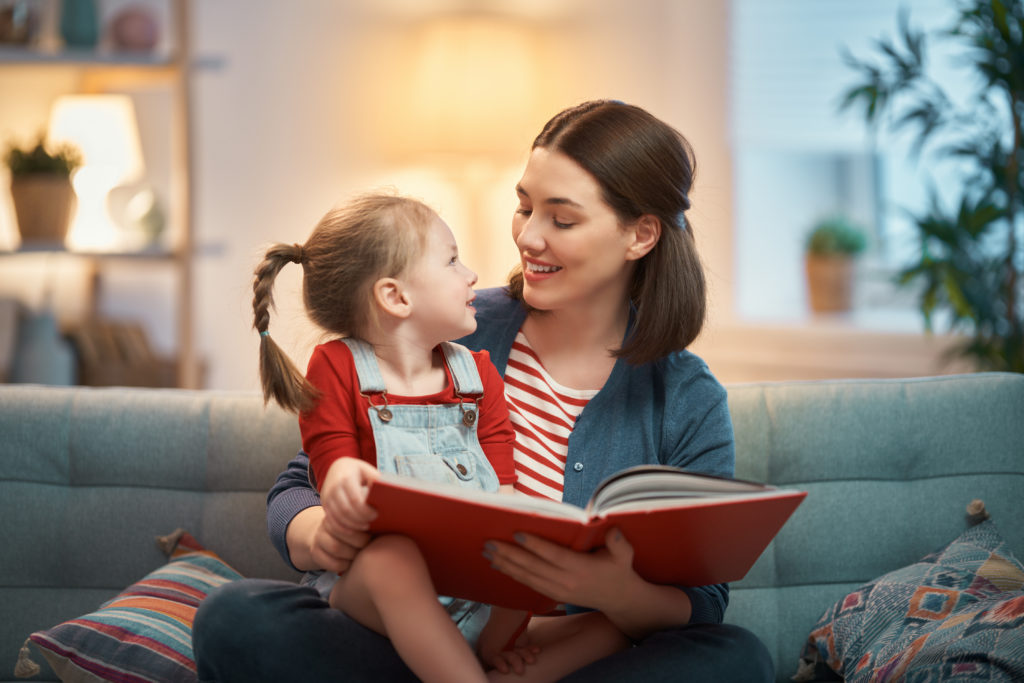 mother reading a book to daughter